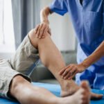 Close up of Physiotherapist working with patient on the bed in clinic